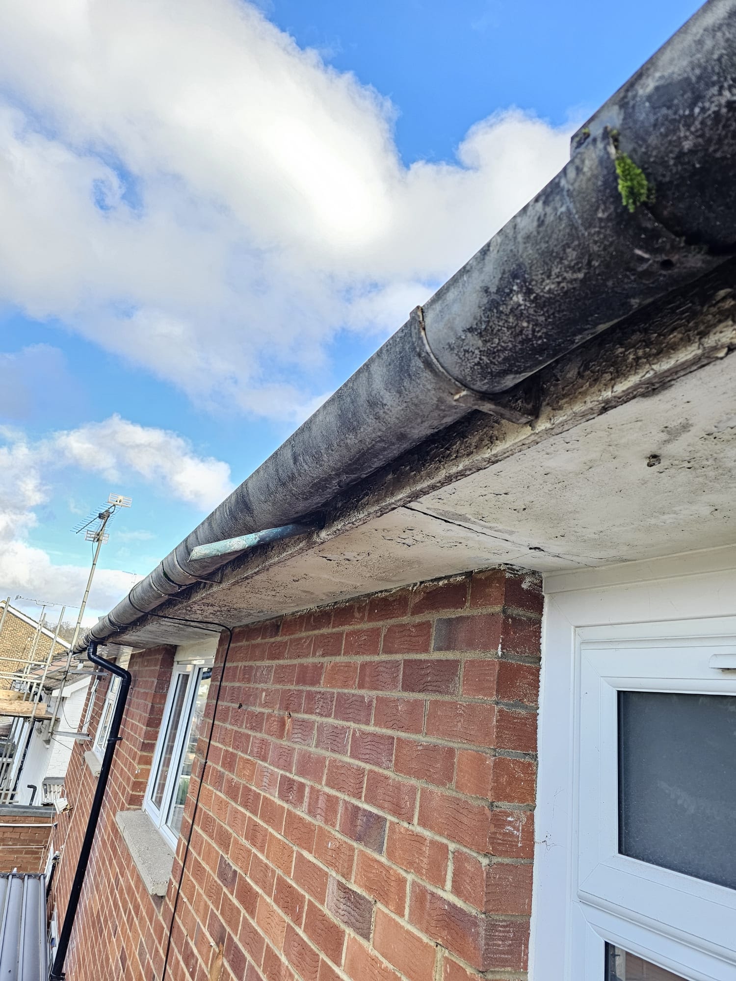 Old concrete soffit and failed guttering — before