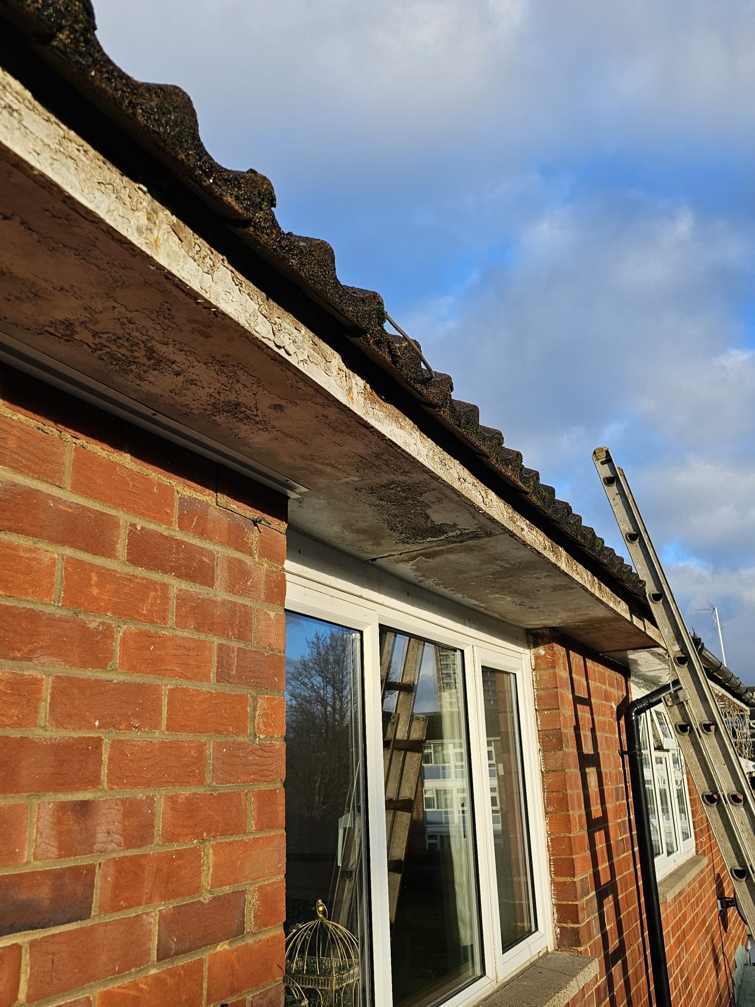 Rotten concrete soffit and old guttering — before replacement