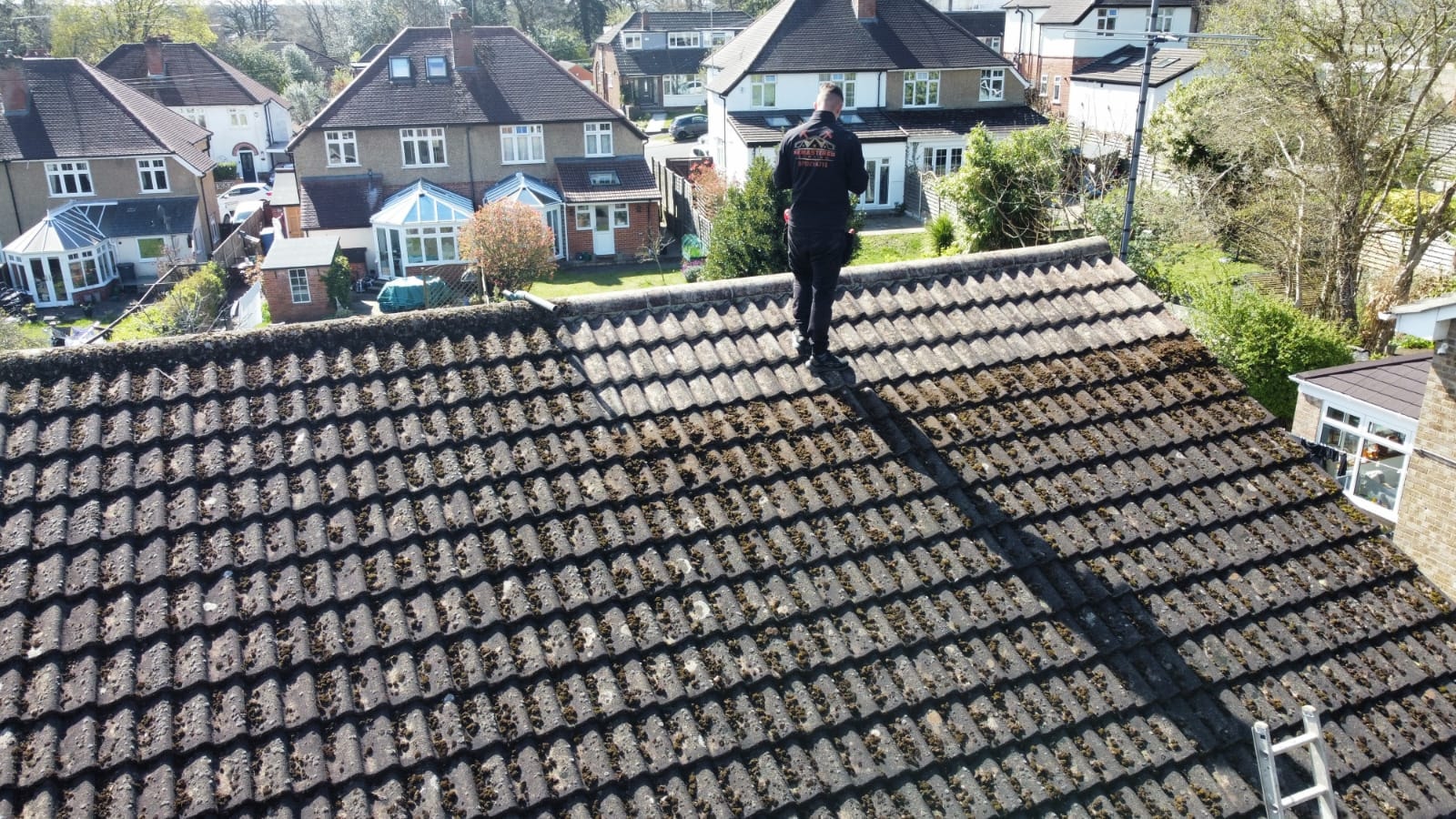 Roofer carrying out moss removal — aerial view